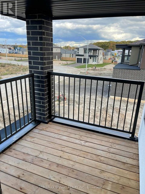 A balcony with a black railing and wooden floor.