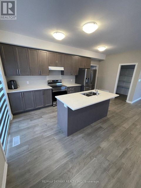 A kitchen with a white countertop and wooden cabinets.