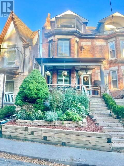 A large house with a front yard and steps leading to the front door.