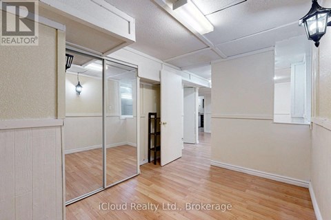 A room with wooden floors and white walls, with a mirror on the wall.
