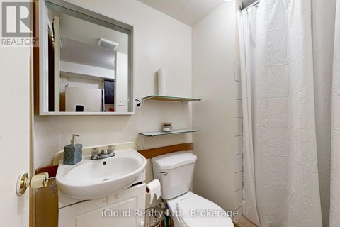 A white bathroom with a sink, toilet and shower.