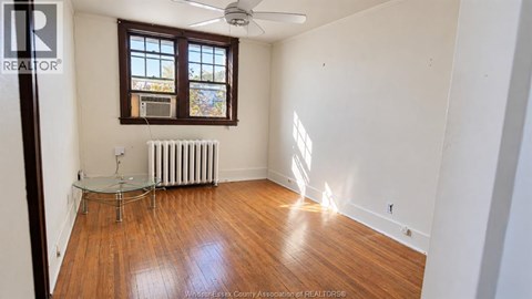 A room with wooden floors and a ceiling fan.