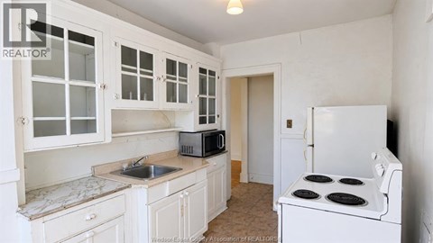 A kitchen with white cabinets and appliances.