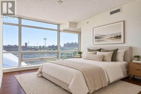 A bedroom with a large bed and a view of the city.