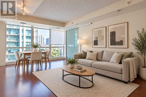 A living room with a couch, coffee table, and a view of the city.