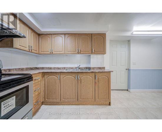 A kitchen with wooden cabinets and a black microwave.