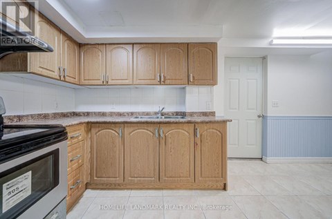 A kitchen with wooden cabinets and a black microwave.