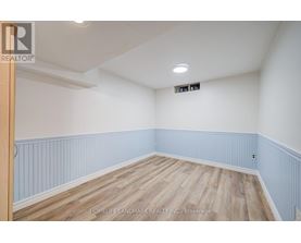 A room with wooden flooring and white walls.