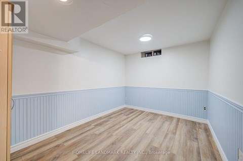 A room with wooden flooring and white walls.
