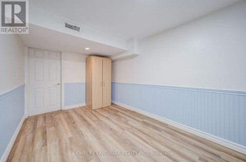 A room with a wooden floor and a white door.