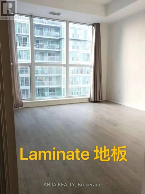 A room with a large window overlooking a building with the words "Laminate" written on the wall.