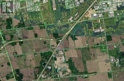 A satellite image of a rural area with a road running through it.