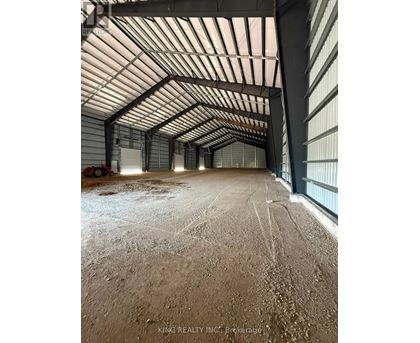 A large, empty warehouse with a high ceiling and metal walls.