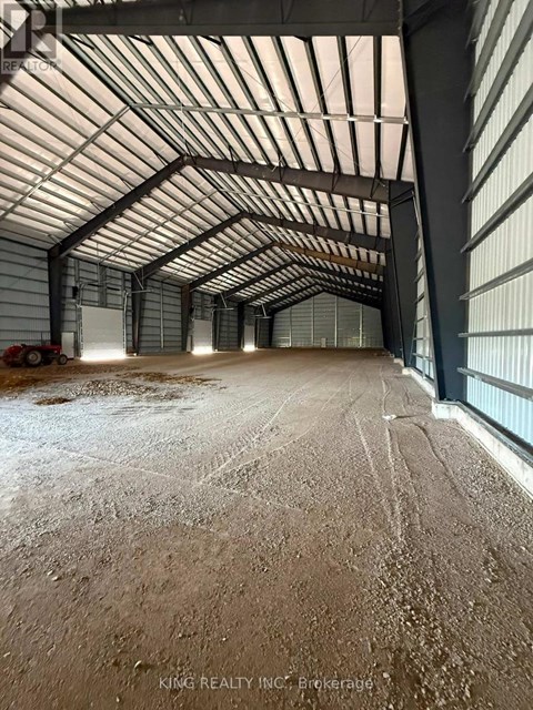 A large, empty warehouse with a high ceiling and metal walls.