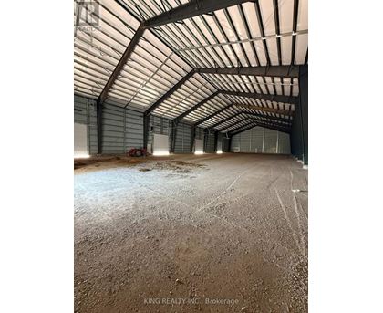 A large, empty warehouse with a high ceiling and a concrete floor.