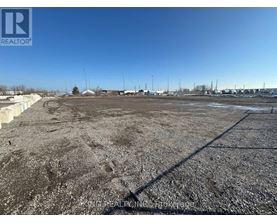A large, empty parking lot with a clear blue sky above.