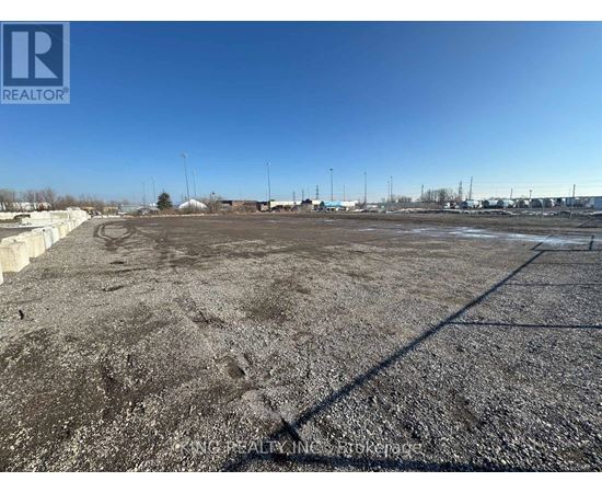 A large, empty parking lot with a clear blue sky above.