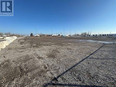 A large, empty parking lot with a clear blue sky above.
