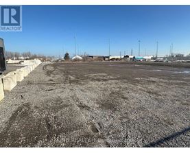A gravel lot with a clear blue sky above.