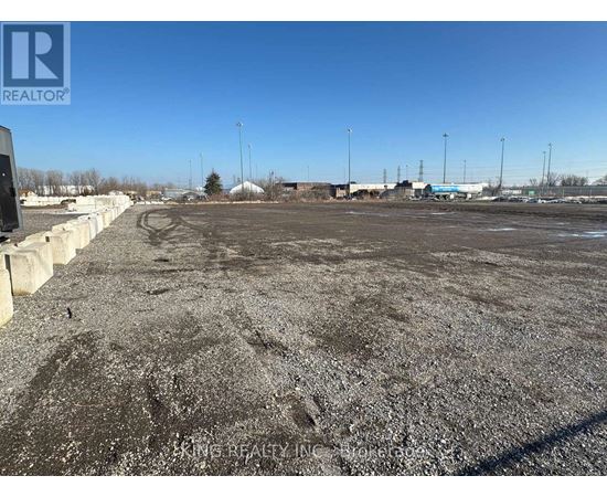 A gravel lot with a clear blue sky above.