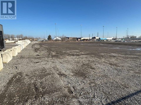 A gravel lot with a clear blue sky above.