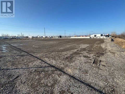 A large, empty parking lot with a clear blue sky above.