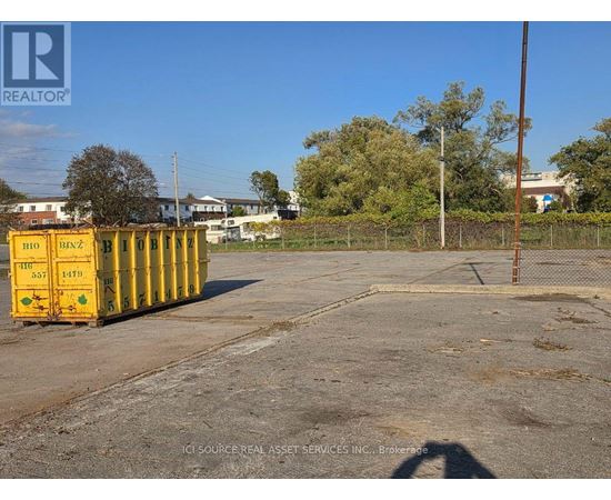 A yellow container with the number 1470 on it is placed in a parking lot.