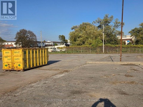 A yellow container with the number 1470 on it is placed in a parking lot.