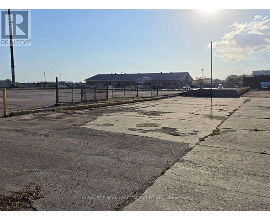 A sunny day at an empty parking lot with a building in the background.