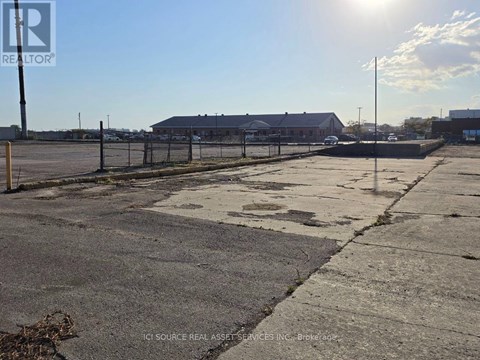 A sunny day at an empty parking lot with a building in the background.