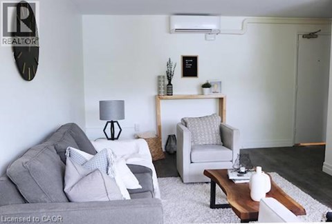 A living room with a grey couch, a white chair, and a wooden coffee table.