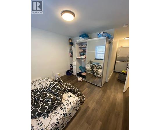 A bedroom with a bed, a wardrobe, and a small table.