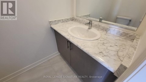 A bathroom with a marble countertop and a sink.