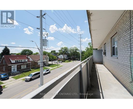 A street view with a Real Broker Ontario Ltd. sign on the building.