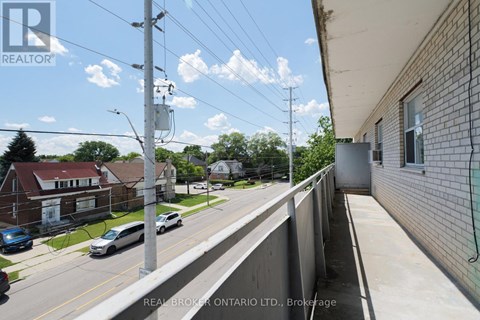 A street view with a Real Broker Ontario Ltd. sign on the building.
