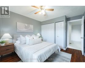 A bedroom with a bed, a ceiling fan, and a rug.
