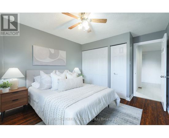 A bedroom with a bed, a ceiling fan, and a rug.