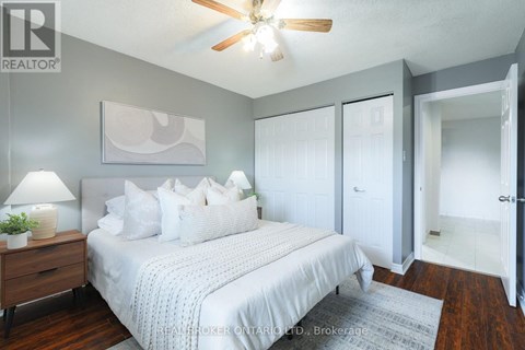 A bedroom with a bed, a ceiling fan, and a rug.