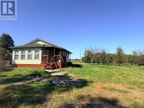 A house with a porch and a green lawn in front.
