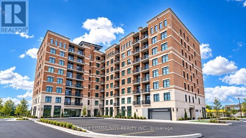 A large brick apartment building with a clear blue sky above.