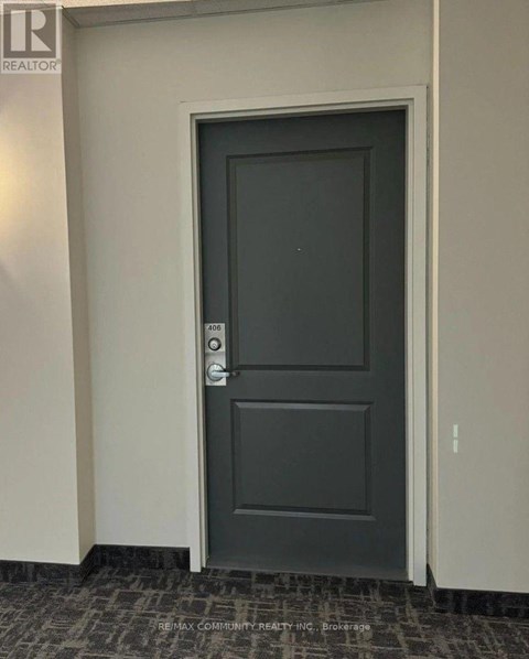 A grey door with a handle and a keypad on the wall.