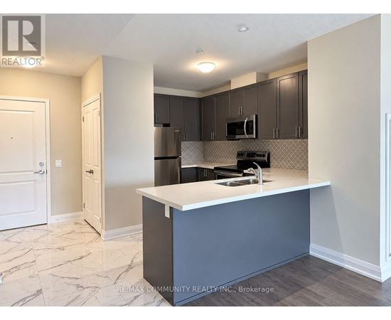 A kitchen with a white countertop and a microwave above it.