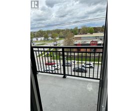 A black metal railing with a view of a parking lot and buildings in the background.