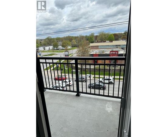 A black metal railing with a view of a parking lot and buildings in the background.