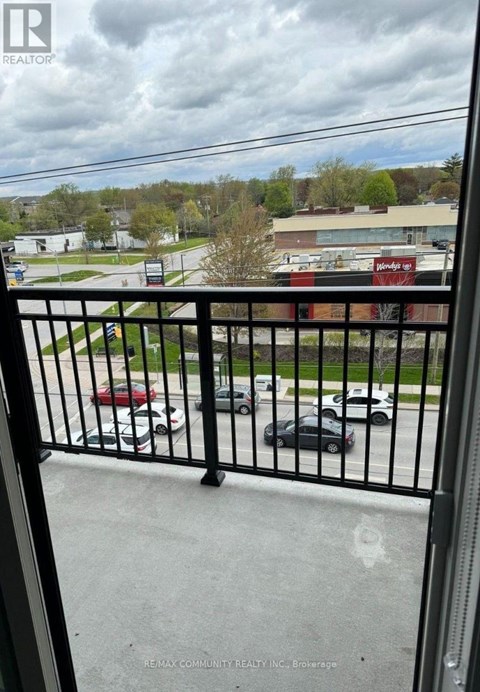 A black metal railing with a view of a parking lot and buildings in the background.