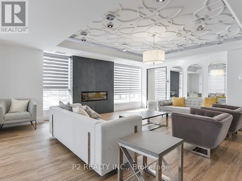 A modern living room with a grey sofa set and a fireplace.