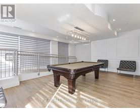 A pool table in a room with a high ceiling and a bench.