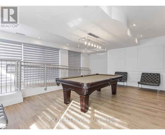 A pool table in a room with a high ceiling and a bench.