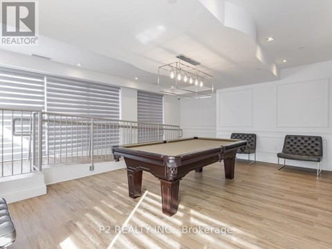 A pool table in a room with a high ceiling and a bench.