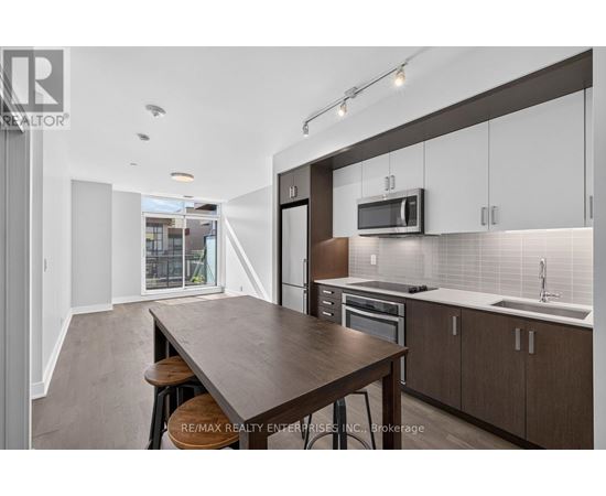 A modern kitchen with a long wooden table and bar stools.